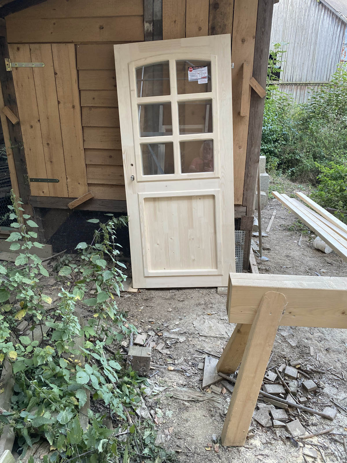 Nebeneingangstüre lehnt am Hühnerhaus und wartet auf ihren Einsatz Nebeneingangstüre lehnt am Hühnerhaus und wartet auf ihren Einsatz