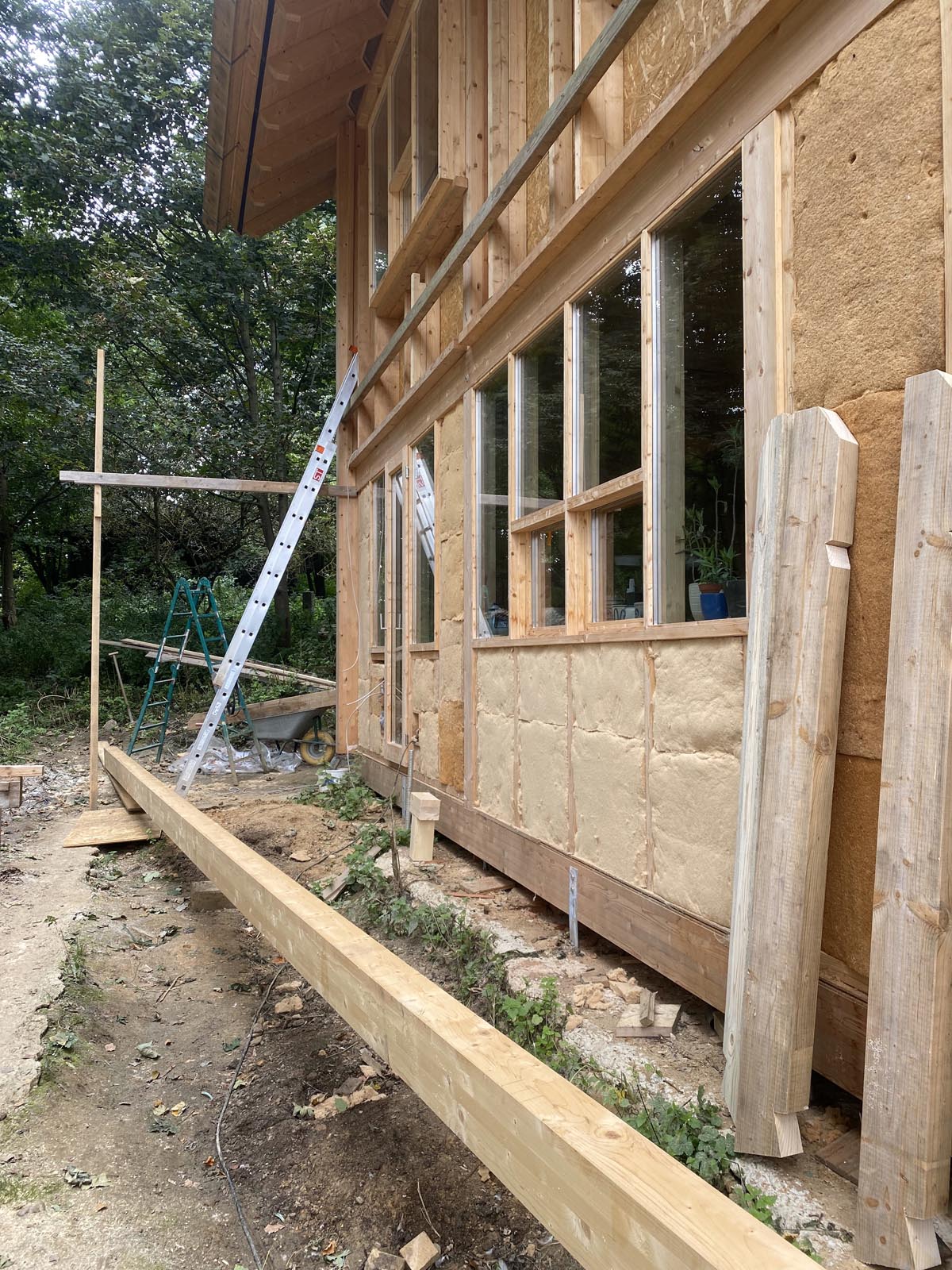 Holzskeletthaus - der First ist schon befestigt, unten liegt die Fußpfette, knapp 200 kg schwer Holzskeletthaus - der First ist schon befestigt, unten liegt die Fußpfette, knapp 200 kg schwer